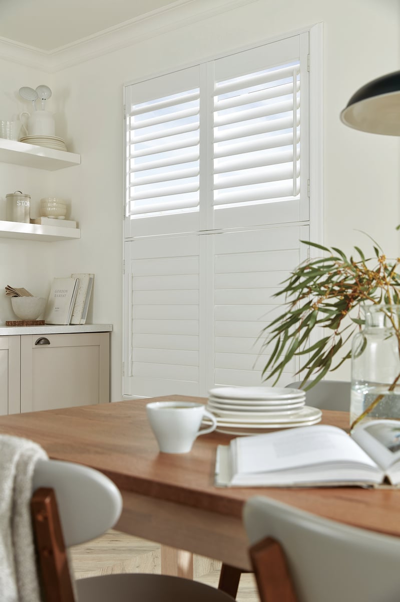 Tier on tier shutters open at top in a green dining room